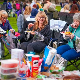 Women sat in deck chairs having a picnic
